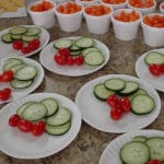 Photo of plates of cucumber, tomato and a cup of carrots. Nutrition area food at the Senior Resource Center.
